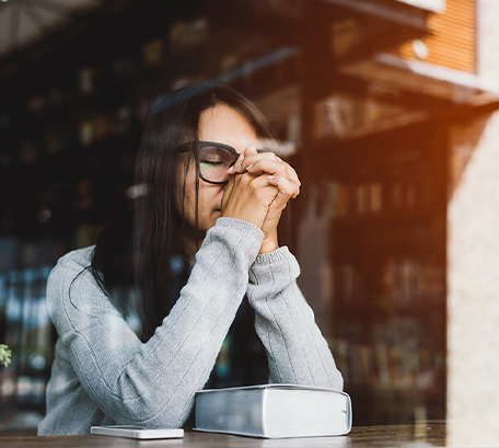 A woman praying inside of a store sitting on a high table