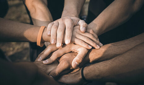 Hands of a group of people touching center